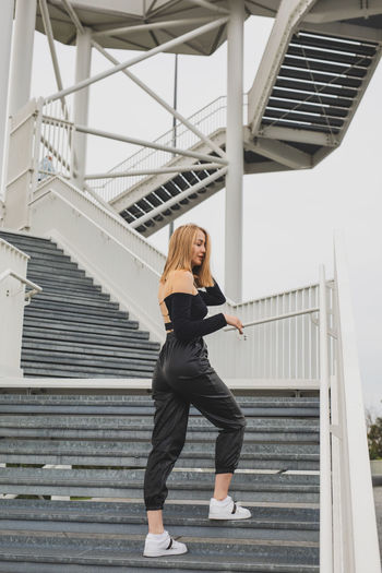 Full length of woman standing on staircase