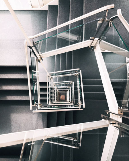 From above of creative spiral stairway with concrete steps and glass banister in contemporary building in hamburg