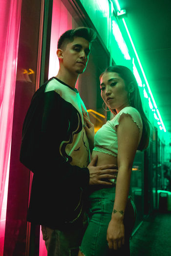 Young couple standing in illuminated room