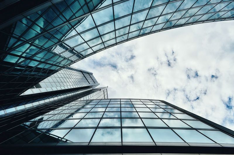 Low angle view of modern building against cloudy sky
