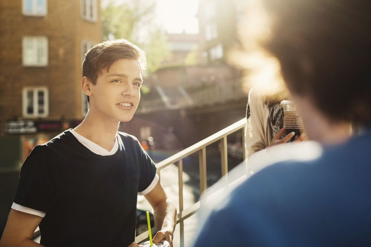 Smiling teenager looking at friend outdoors