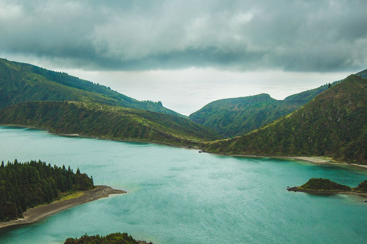 Scenic view of lake by mountains against sky