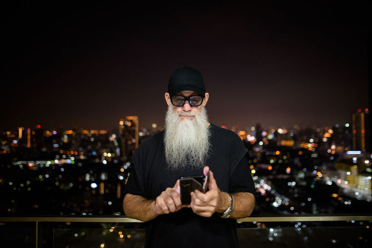 Full length of man using mobile phone at night