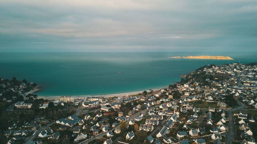 High angle view of townscape by sea against sky