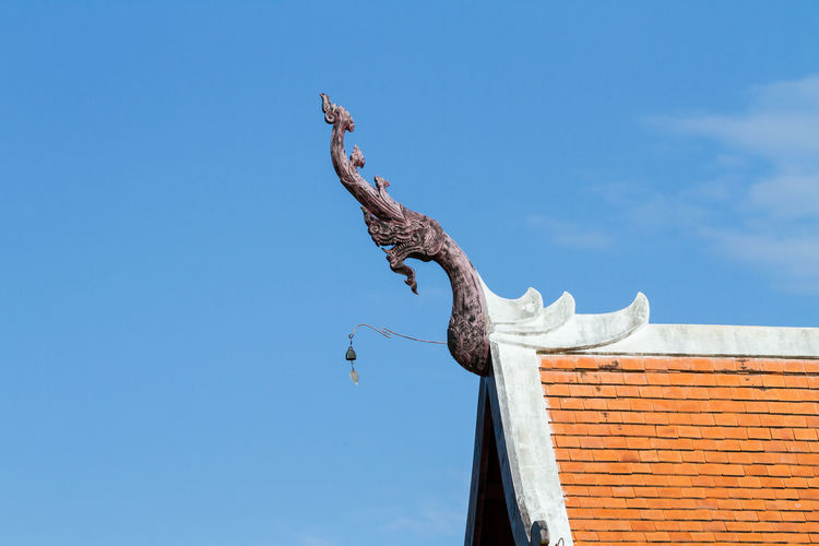 Low angle view of dragon sculpture on roof against sky at royal flora ratchaphruek