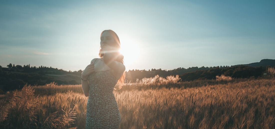 Woman standing on field against sky