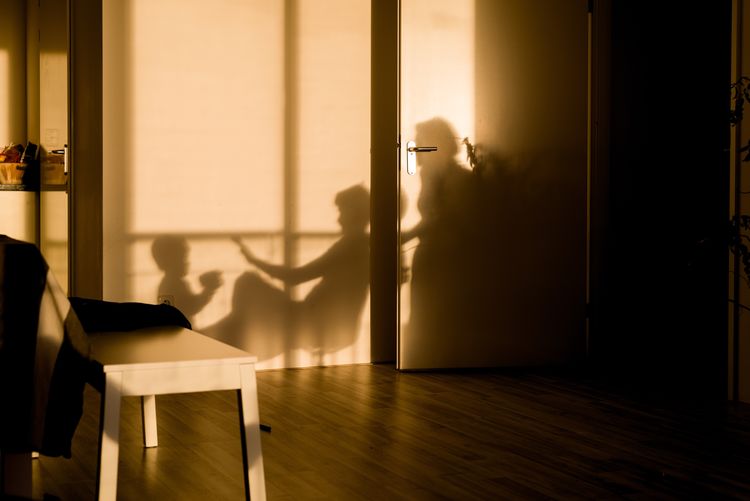 Shadow of parents playing with child at home