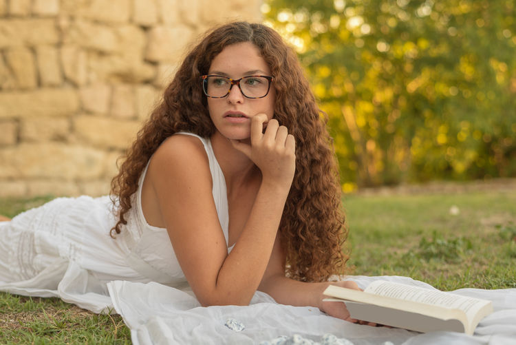 Portrait of a young woman sitting on book