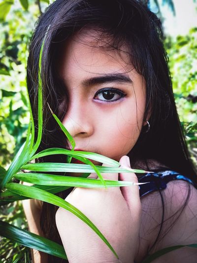 Close-up portrait of girl holding plant