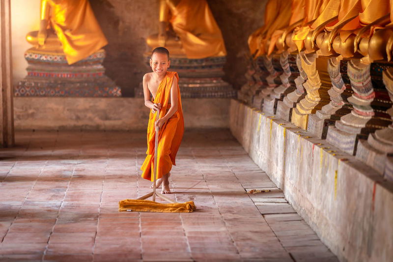Full length of boy cleaning temple