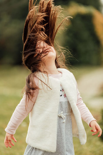 Girl looking away while standing outdoors