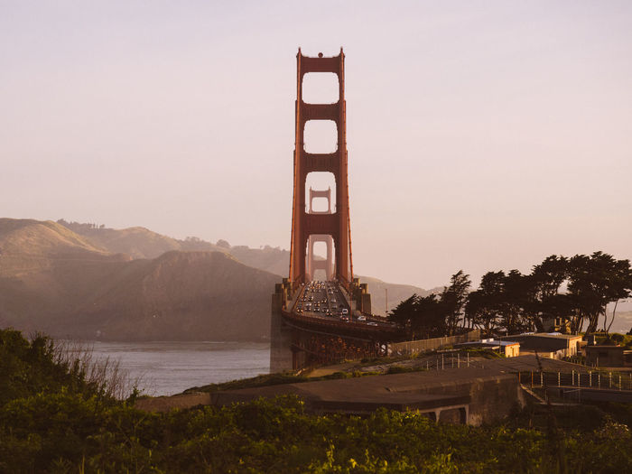 Golden gate bridge over san francisco bay by mountain against sky during sunset