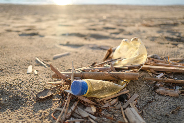 Dirty aged plastic bottle trash discarded on sea coast ecosystem,environmental pollution issues
