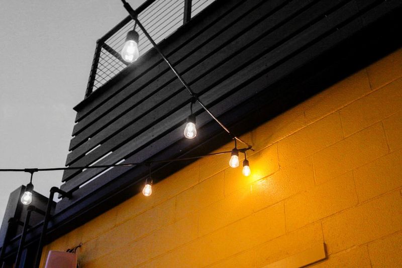 Low angle view of illuminated lamp hanging in city