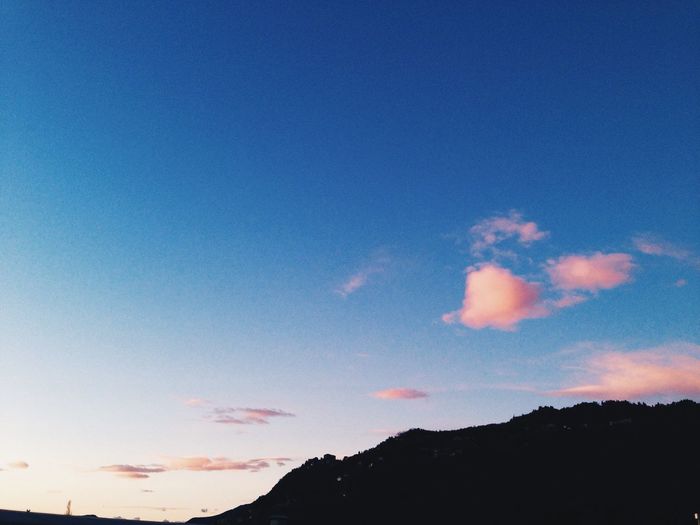 Scenic view of mountains against blue sky