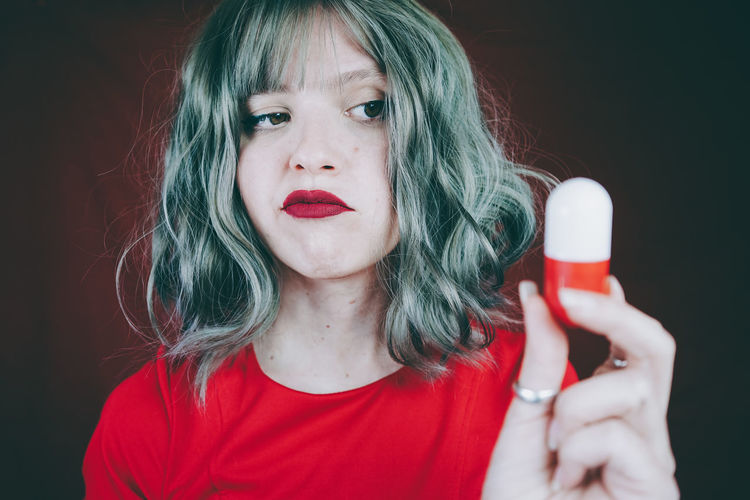 Woman with gray hair looking at capsule