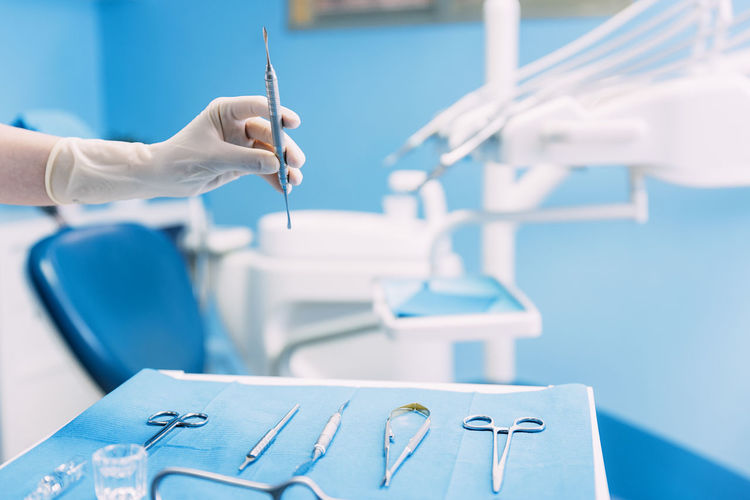 Cropped hand of dentist holding dental equipment at clinic
