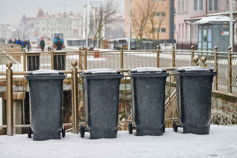Garbage bin by street in city during winter