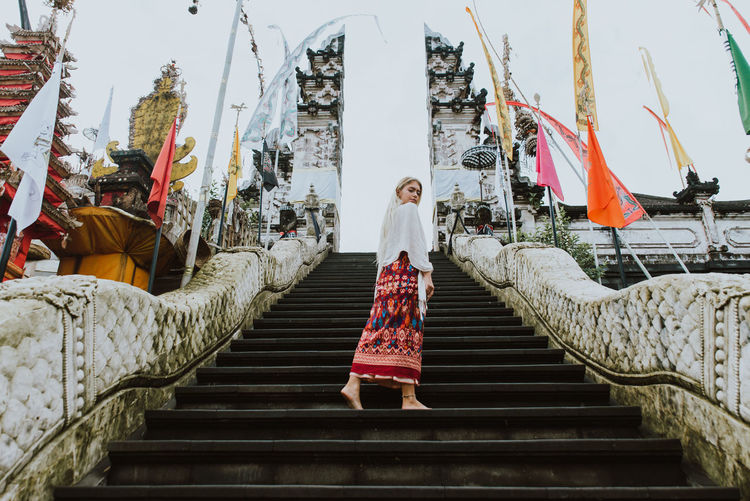 Young woman standing on steps at temple gate