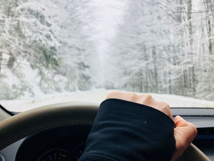 Cropped hand driving car during winter