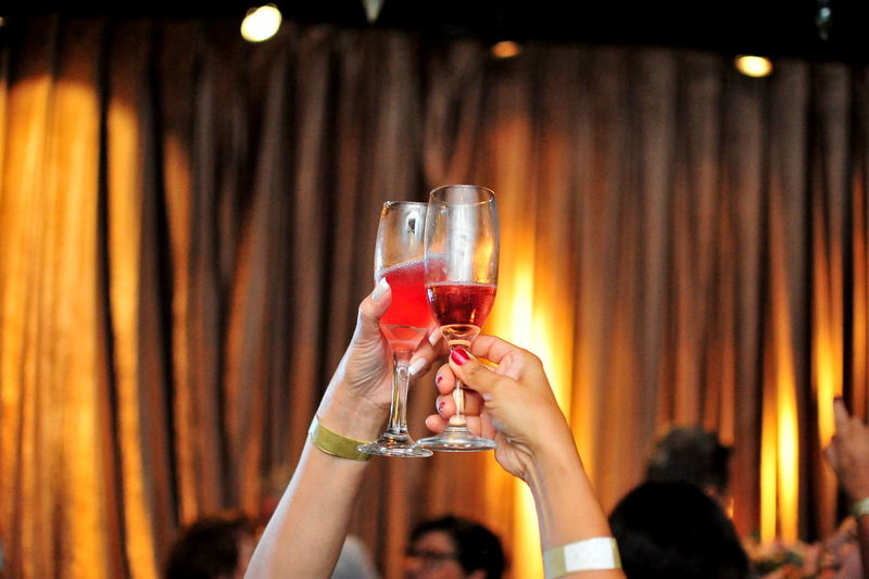Cropped image of hands toasting drinks at party