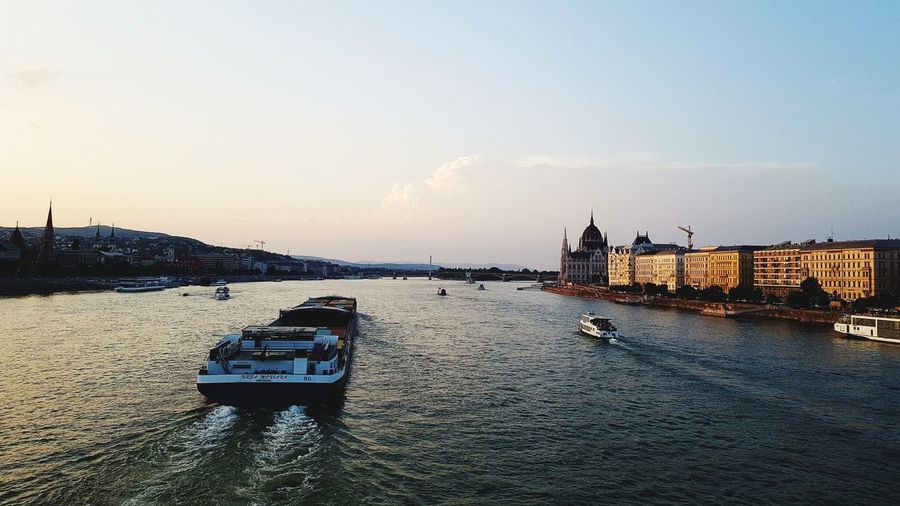 Boat in river with city in background
