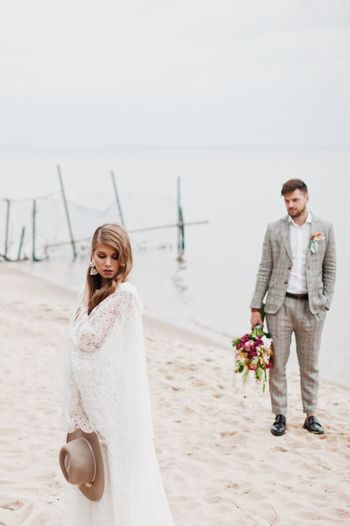 Bride and bridegroom standing at beach during wedding ceremony
