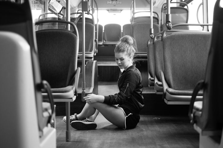 Full length of beautiful woman sitting in bus