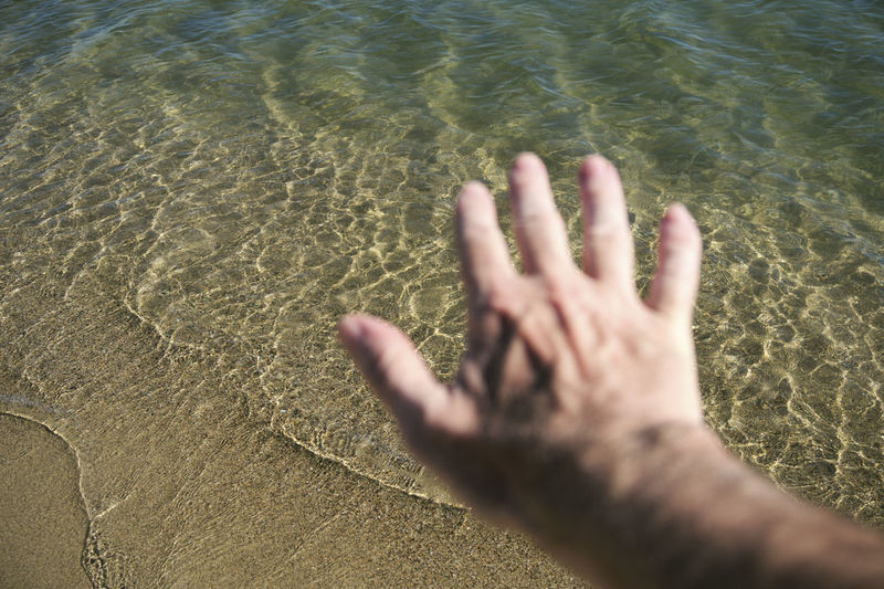 Close-up of hand over water