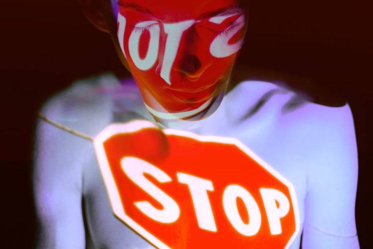 Close-up of shirtless man with light on body against black background
