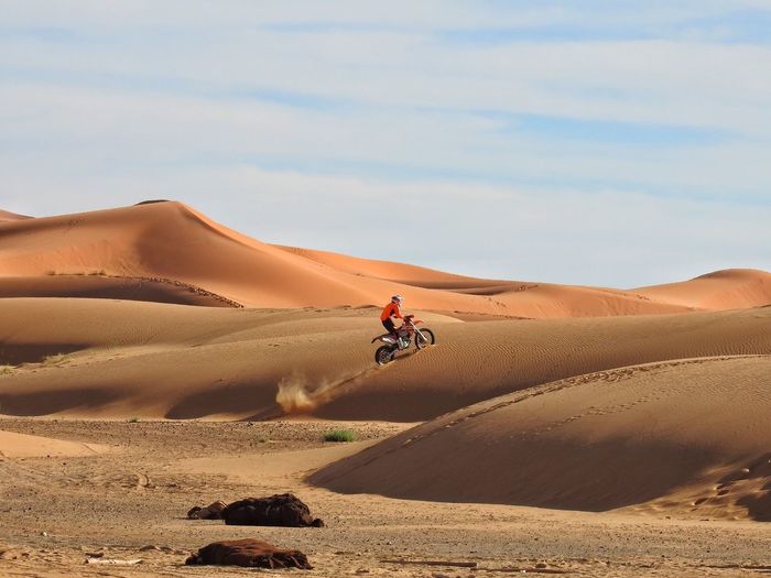 Side view of man bicycling at desert