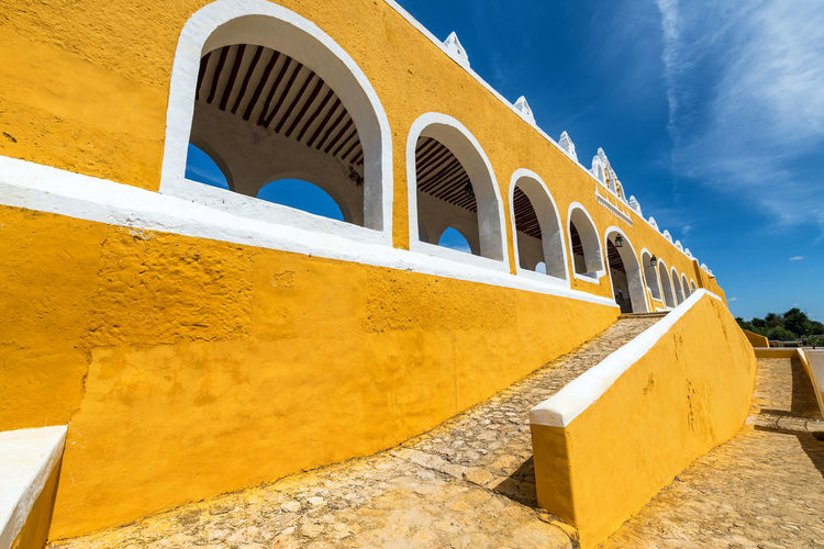 Low angle view of yellow monastery against sky