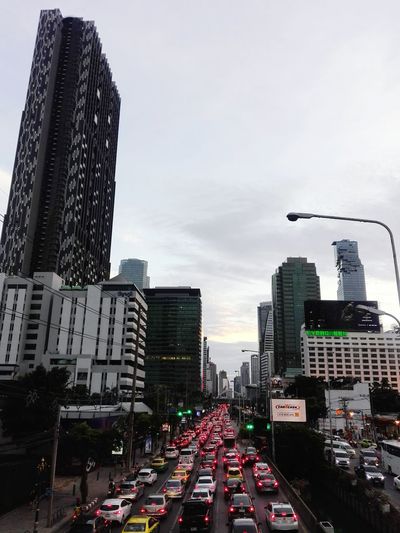 Traffic on city street and buildings against sky