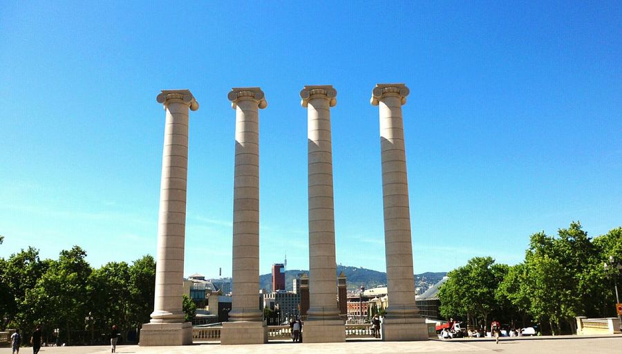Low angle view of pillars against clear blue sky