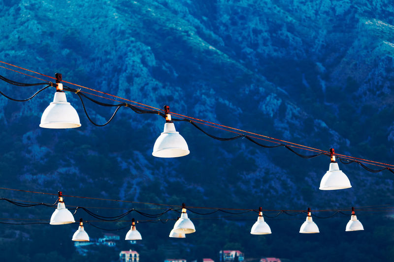 Hanging white street lamps , mountains on background