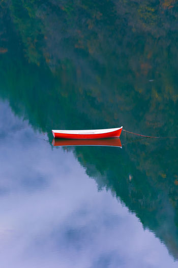 Red boat moored in lake