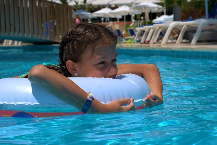 Girl with an inflatable circle swims in the pool