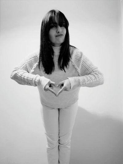 Portrait of woman standing against white background