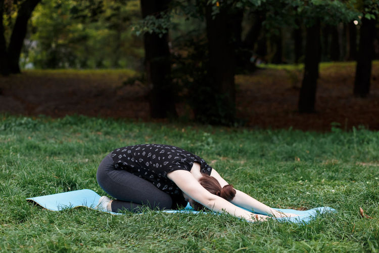 Woman lying on grass in park