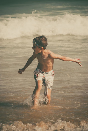 Shirtless boy playing at beach