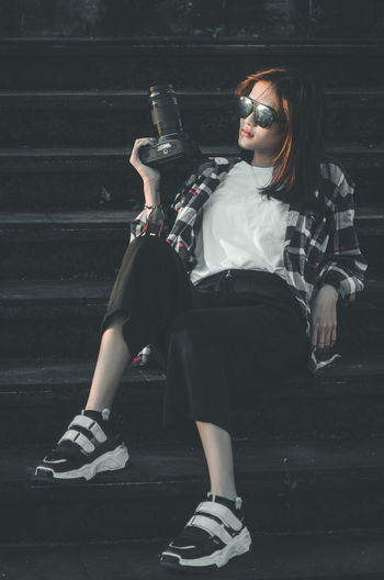 Full length of young woman sitting on seat