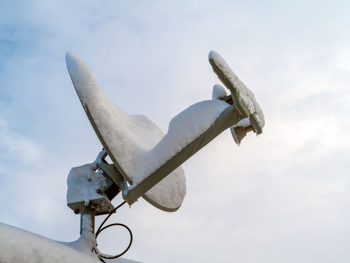 Rooftop satellite dish covered in snow with copy space.