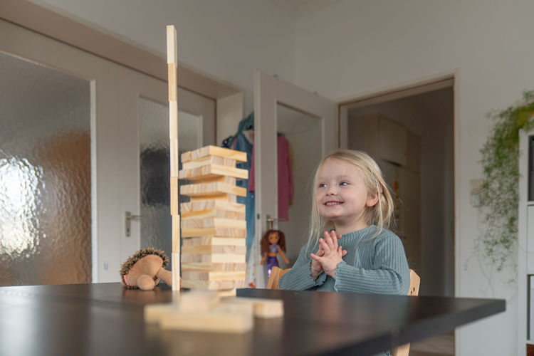 Toddler girl is looking excited on a wooden tower