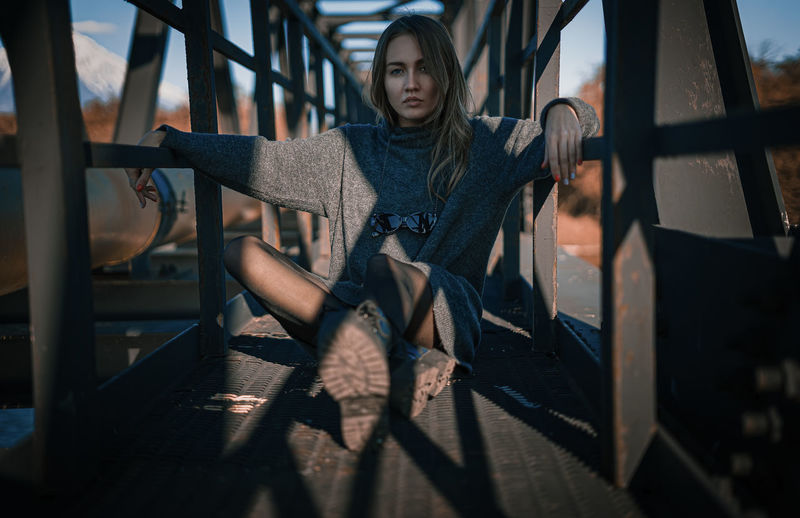 Young woman sitting on railing
