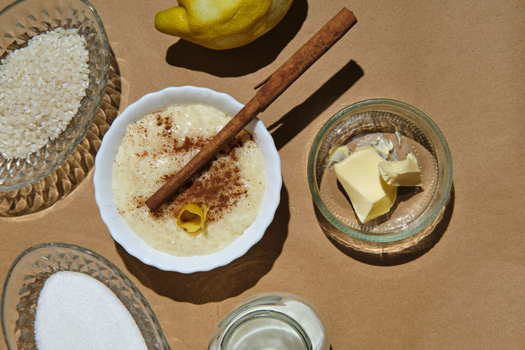 Rice pudding with its ingredients on a brown background