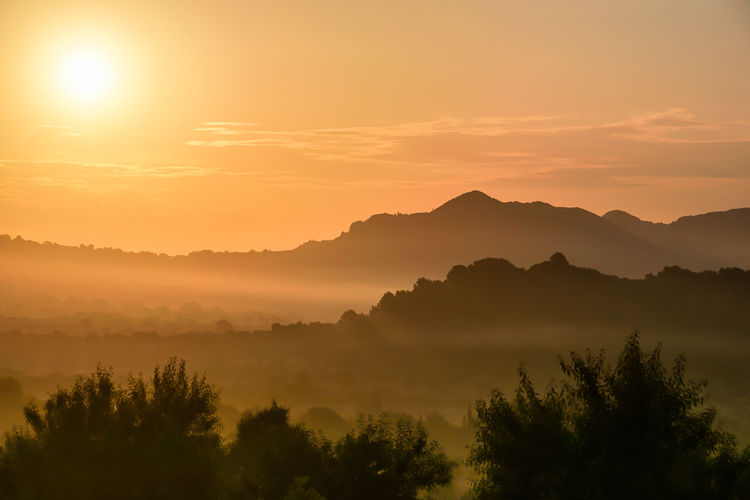 Scenic view of silhouette mountains against sky during sunset