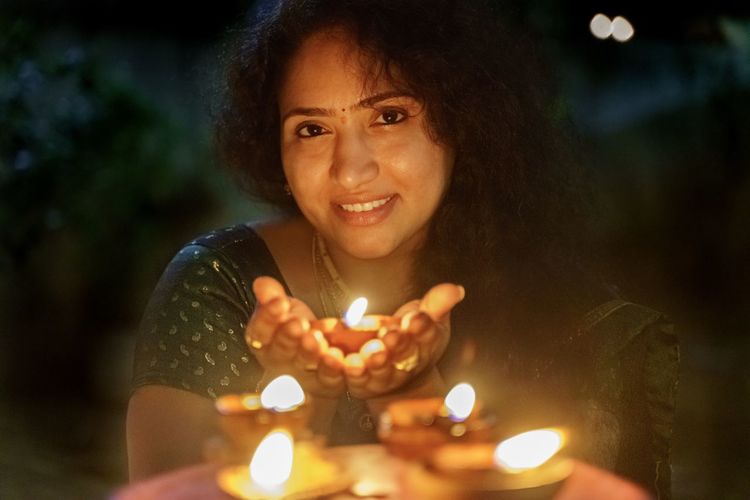 Close up of a young female holding a diya