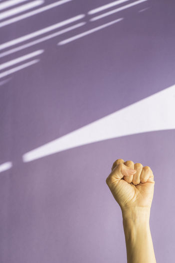 Cropped hand of woman against wall at home