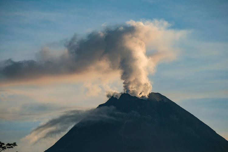 Smoke emitting from volcanic mountain against sky