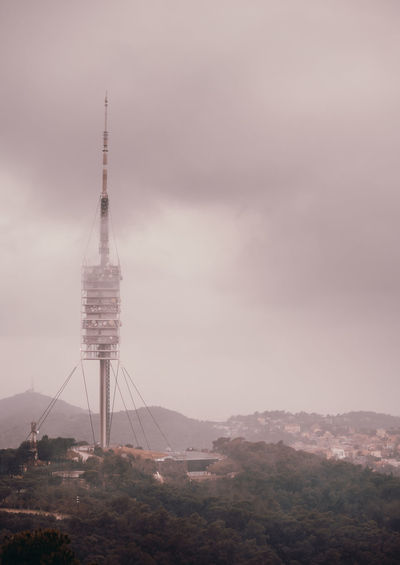 Communications tower and buildings against sky
